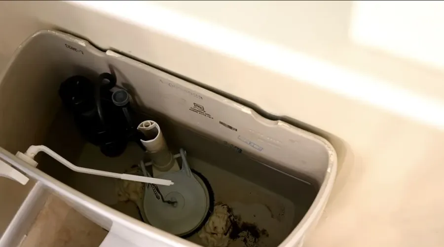 打開的馬桶水箱,裏面裝好了新的皮塞和沖水閥鏈條