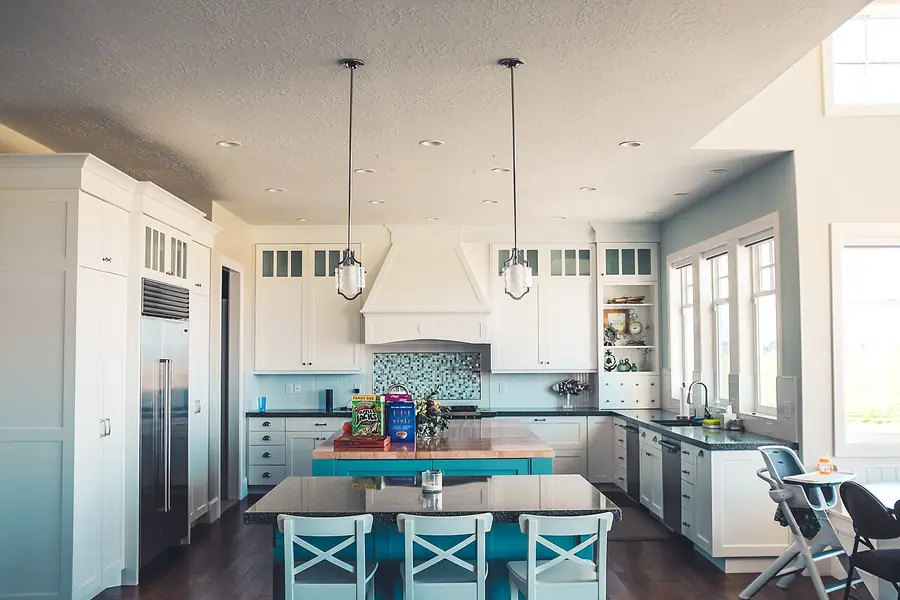 Kitchen with white upper cabinets and blue lower cabinets