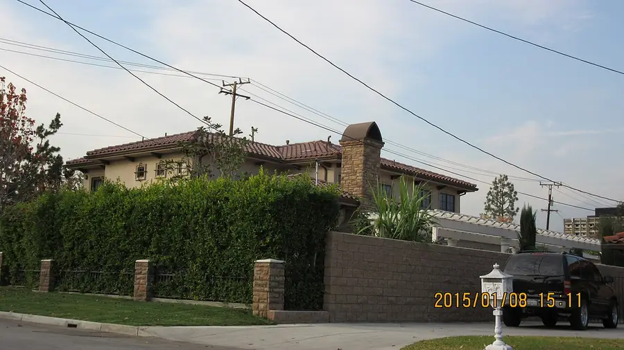 Two-story single-family home behind a hedge on a quiet Arcadia street