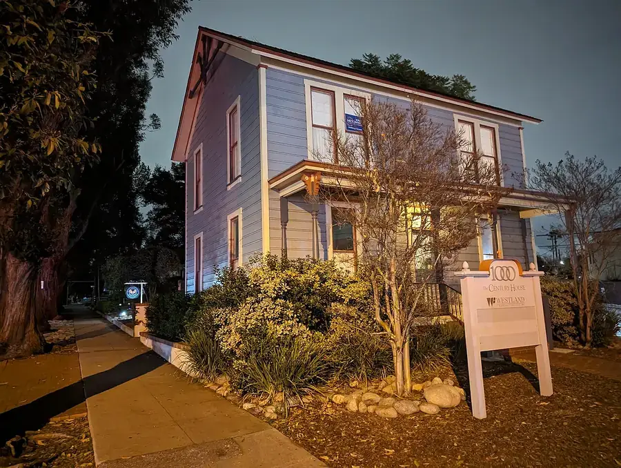 Restored two-story Century House with a historic marker in South Pasadena