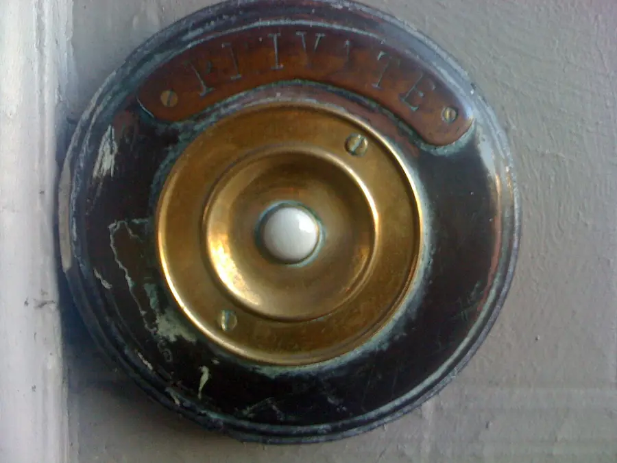 Round brass doorbell button with a white push center in a metal ring