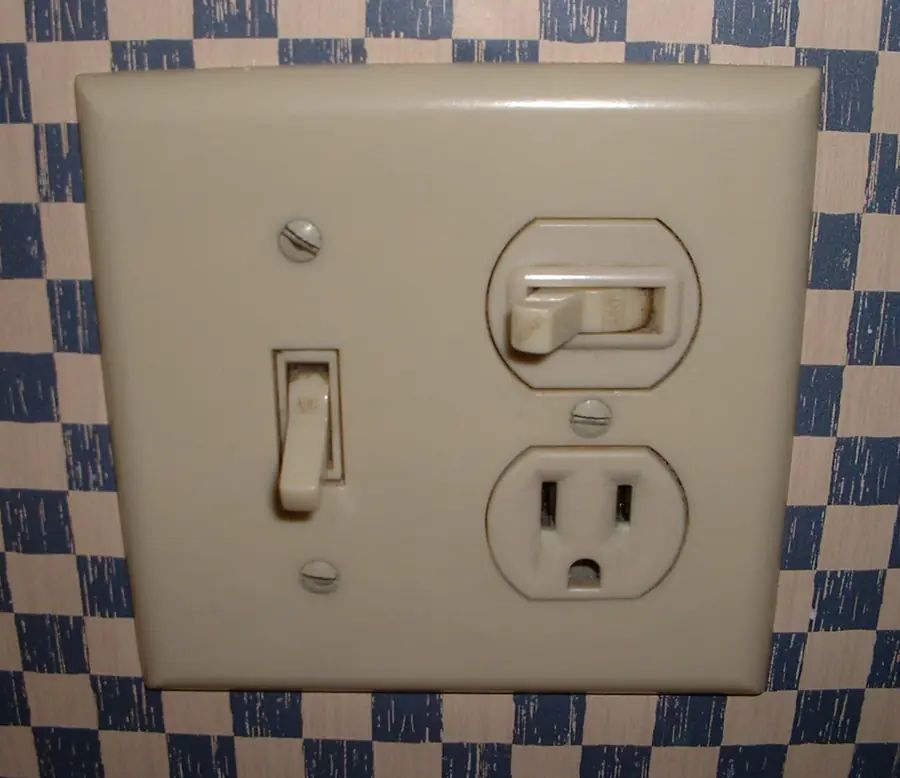Combination light switch and outlet in a single wall plate