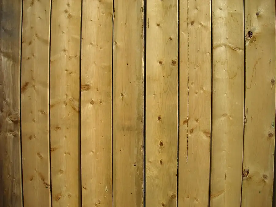 Close view of new vertical wood fence boards with natural grain and knots