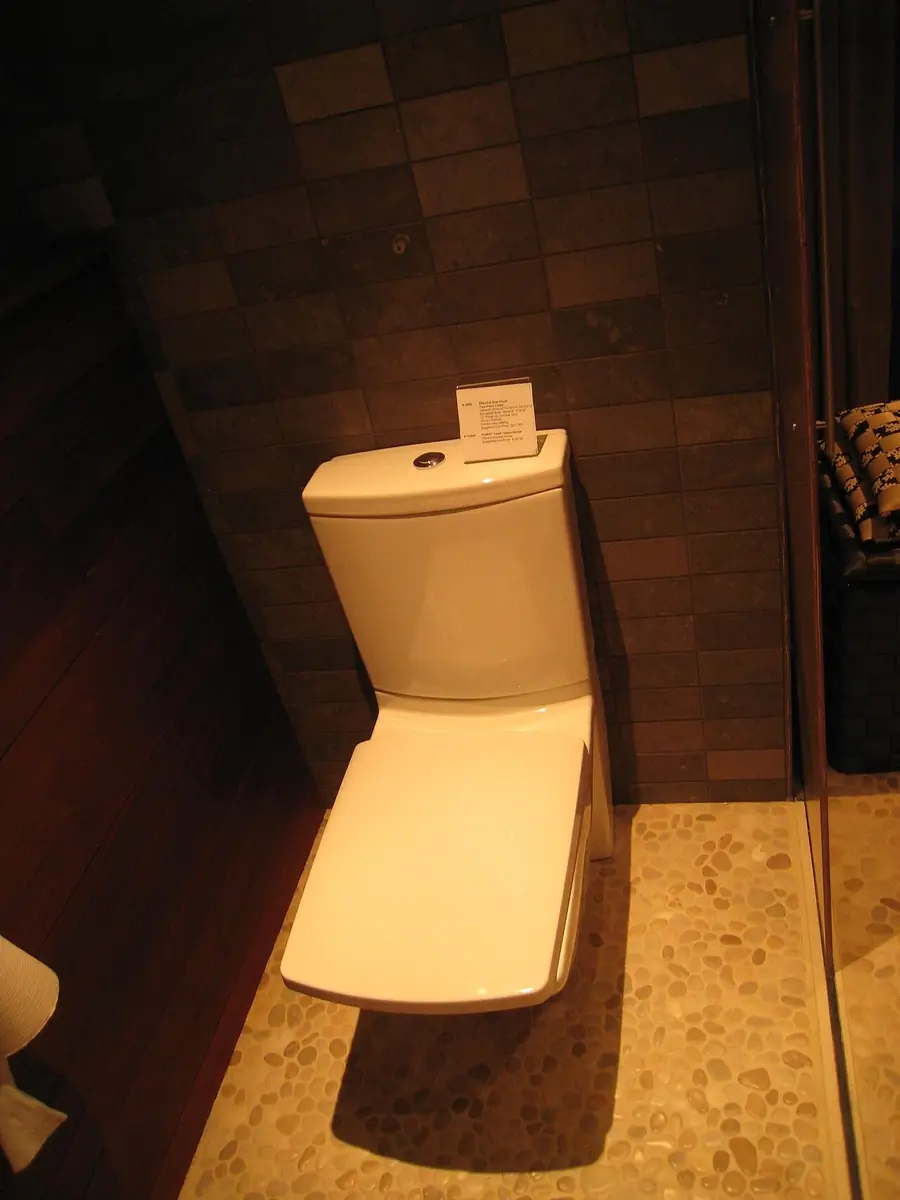 Modern one-piece toilet against dark tile walls in a display bathroom