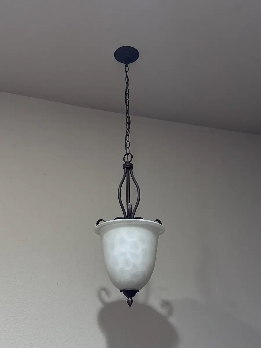 White glass pendant light hanging from a ceiling