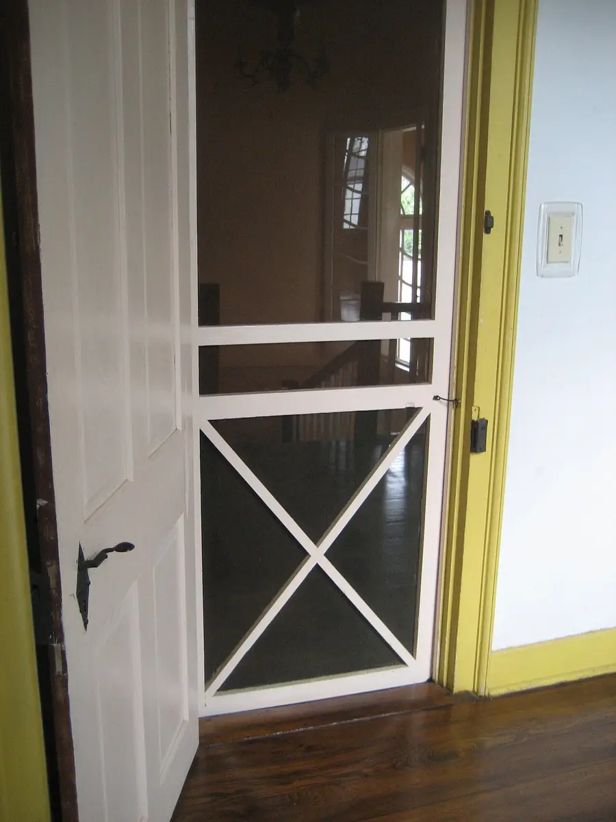 Interior wood screen door with an X brace below the mesh panel