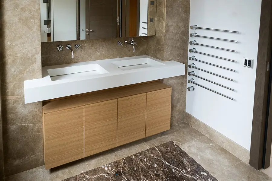 Bathroom vanity with a long wall mirror, wood cabinets and two sinks