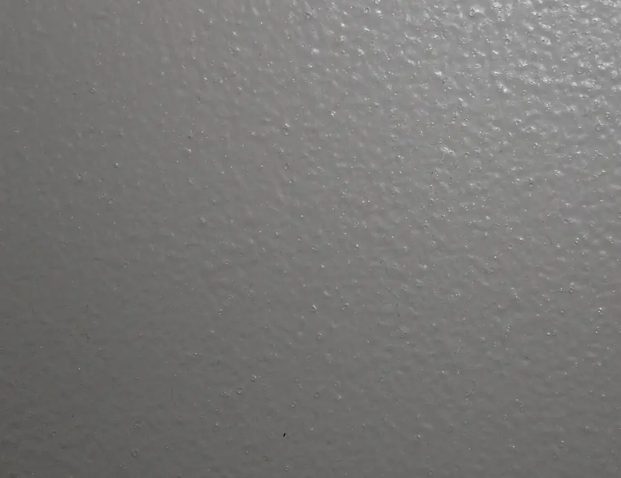Close view of a gray painted drywall surface with a light texture