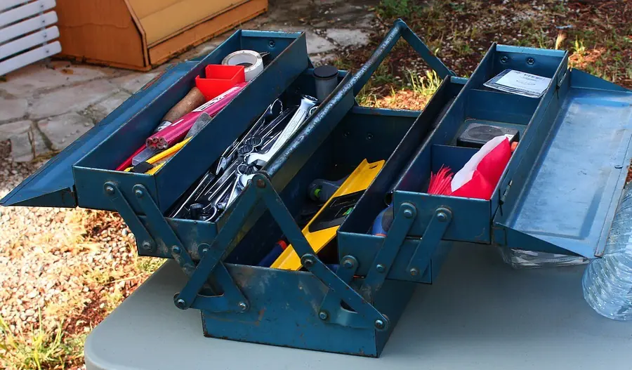 Open blue metal toolbox with trays of small hand tools