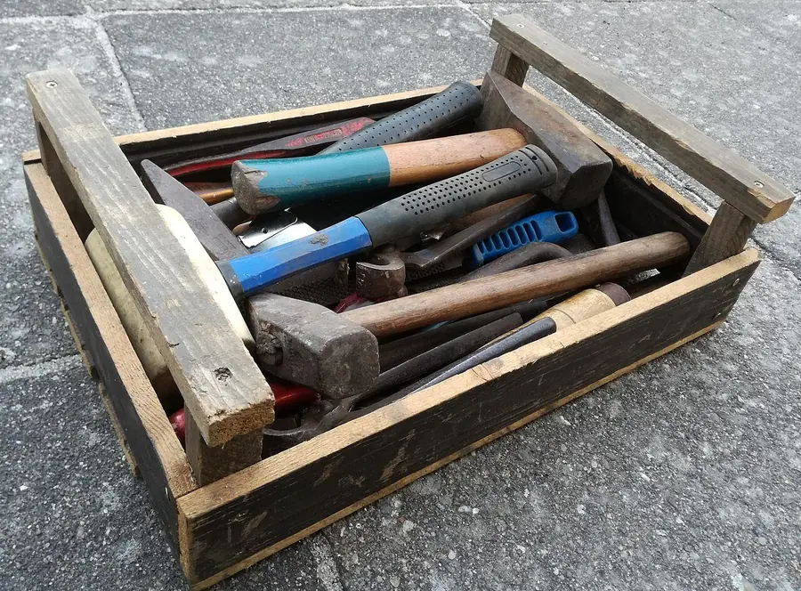 Old wooden toolbox holding hammers, a mallet and other hand tools