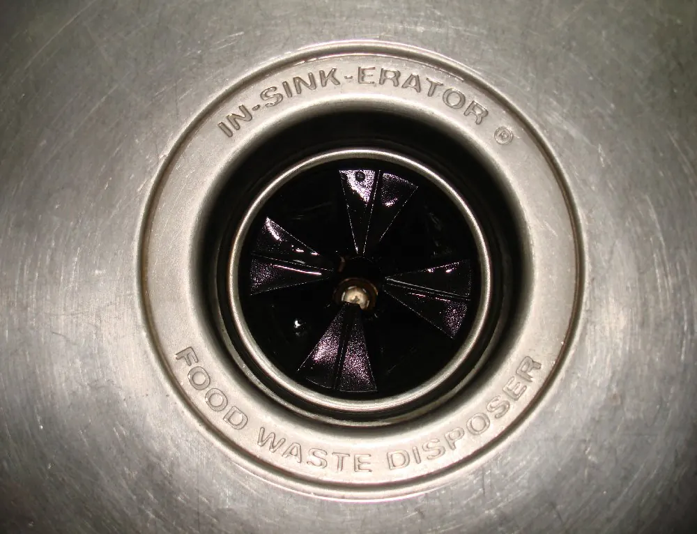 Kitchen sink drain opening with a garbage disposal splash guard