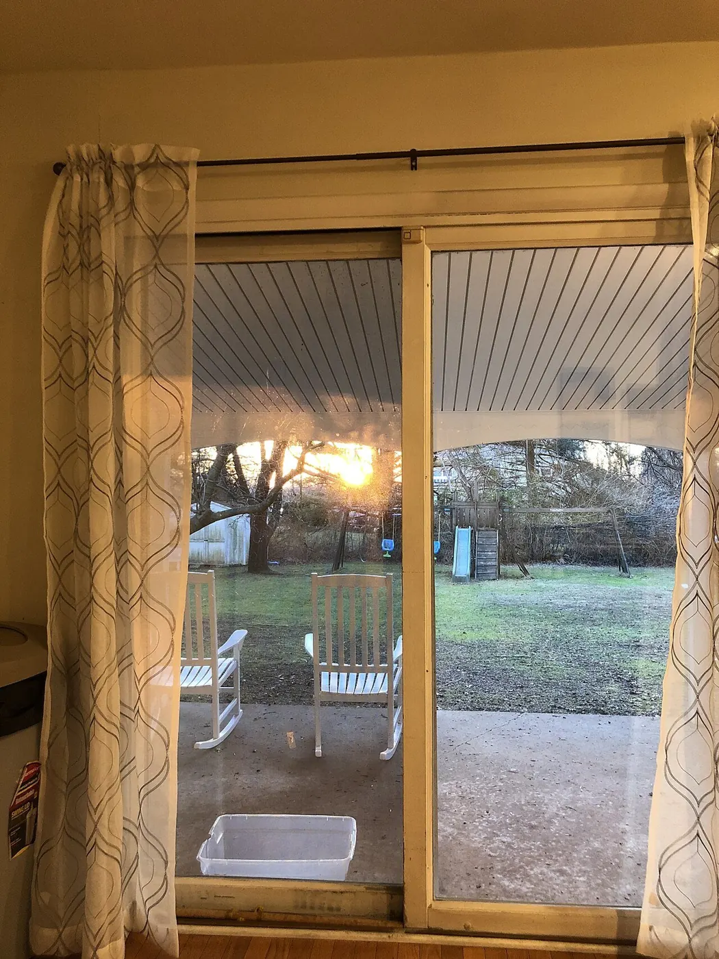 Evening light through a sliding glass door with curtains