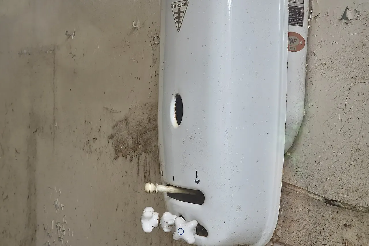 Old tank water heater with worn, dirty casing