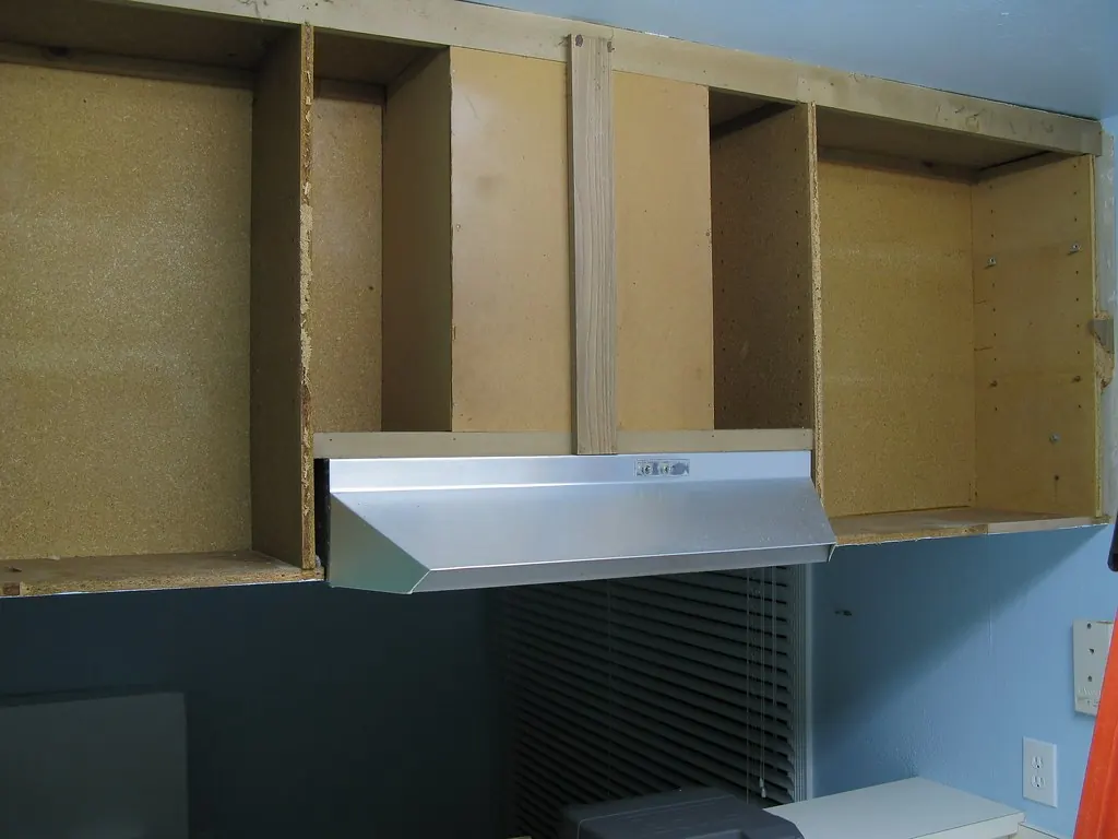 Range hood mounted over a stove in a kitchen being worked on