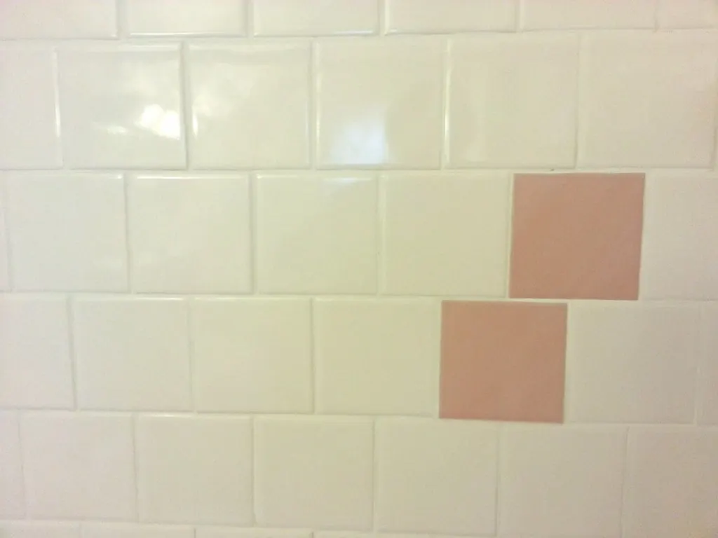 Wall tiles with fresh grout lines above a tub