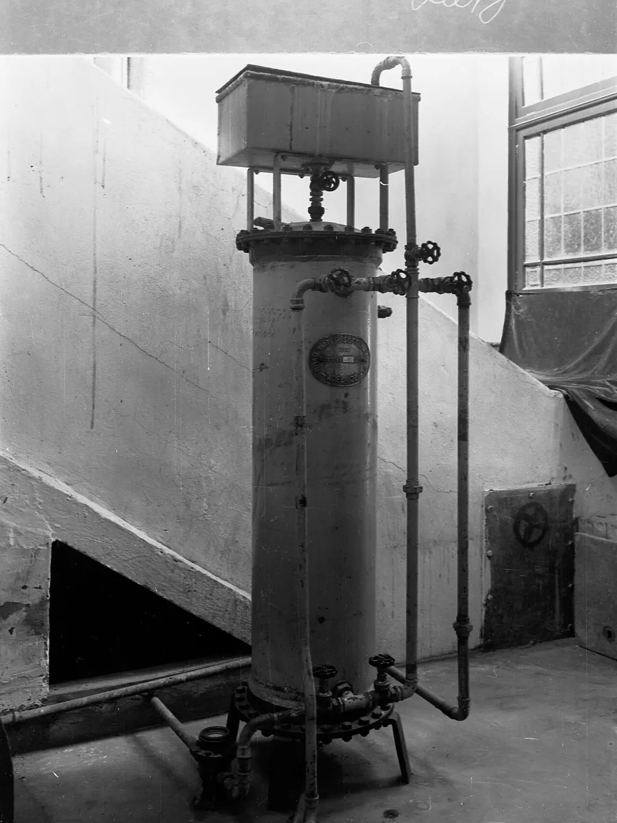 Older single-tank water softener with its control valve on top