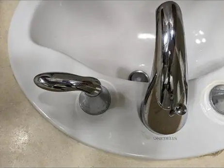 Chrome single-handle faucet on a white bathroom sink, seen from above