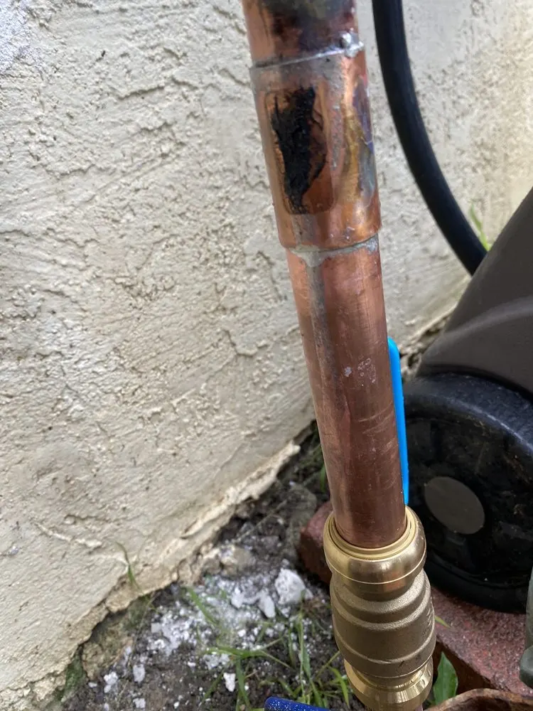 灰泥墙边带黄铜户外龙头接头的铜水管