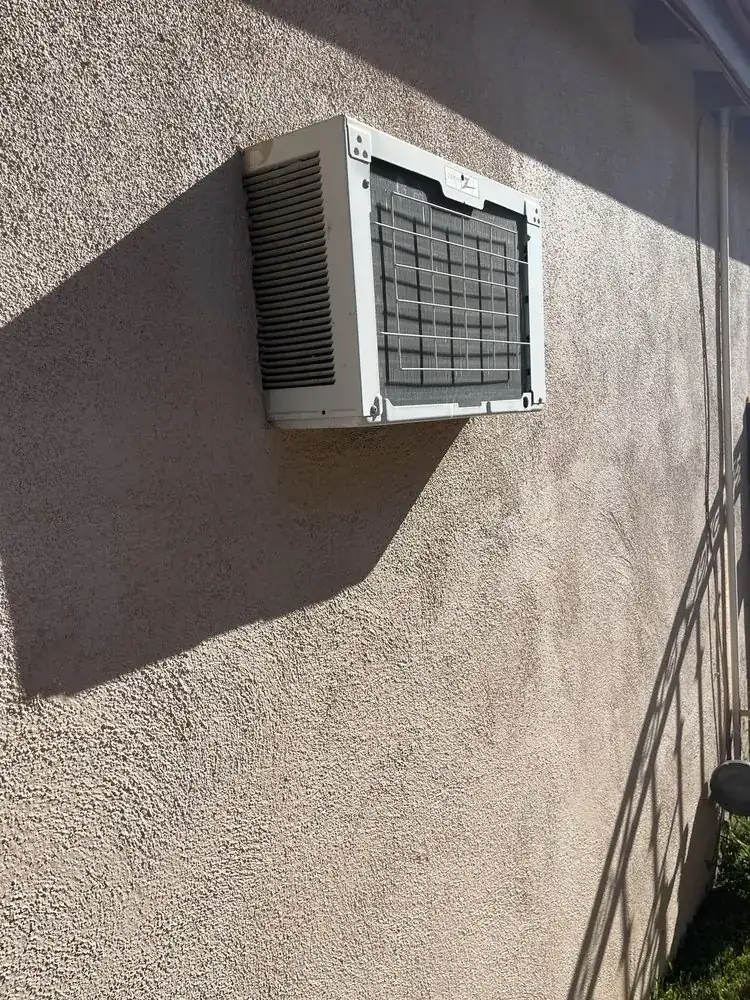 Textured stucco wall around a through-wall air conditioner sleeve