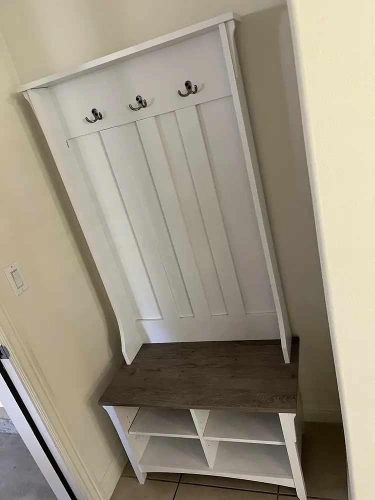Entry bench with coat hooks assembled against a wall
